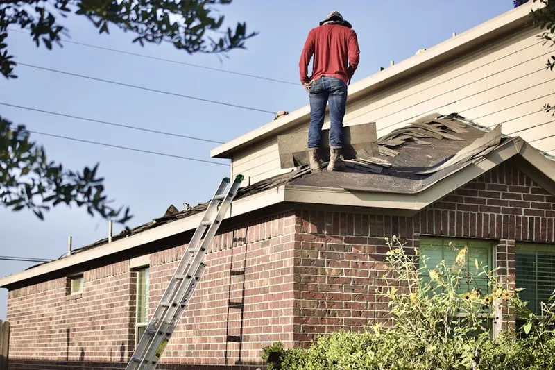 Professional roofer working on a residential roof in Maravilla Housing Project